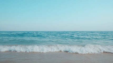 calm beach horizon with gentle waves lapping against sandy shore under clear blue sky