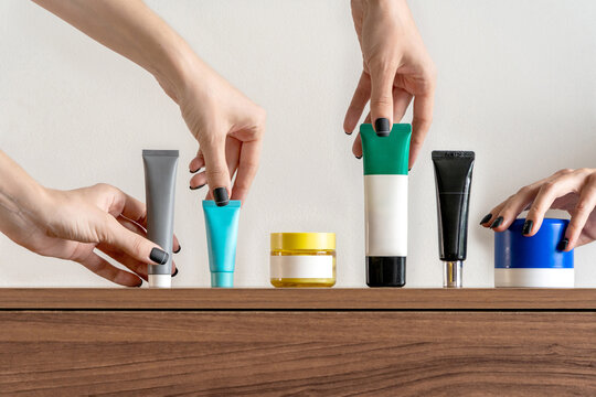 Anonymous hands taking cosmetic products from a shelf