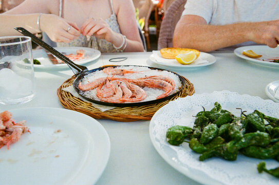 Prawns and padron peppers with anonymous diners