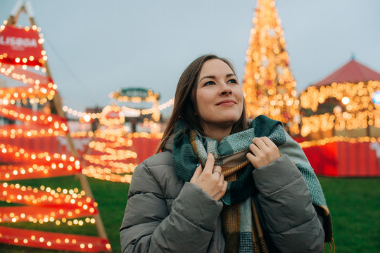 Woman with scarf in festive market during winter holiday season