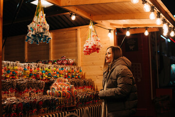 Woman looking at colorful candies at a festive Christmas market