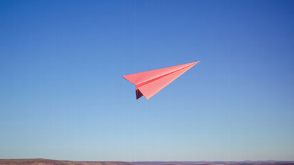 vibrant paper airplane soaring through clear blue sky, symbolizing freedom and creativity. Its bold red color stands out against serene backdrop, evoking sense of joy and adventure