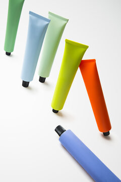 Creative arrangement of colorful skincare tubes on a white background