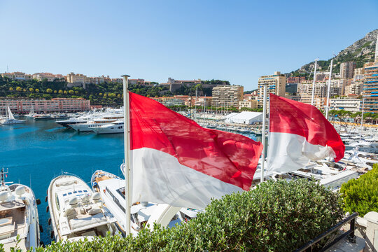 Flag of Monaco with Monaco Marina in the background.
