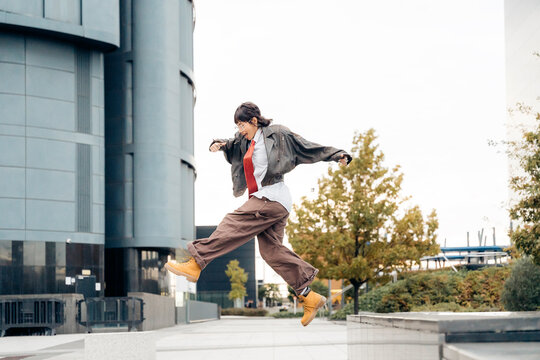 Young woman performing a powerful jump in an urban setting