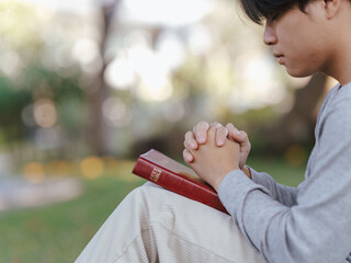 Christian pray and worship god with belief and spirituality. Hand praying and praise with the holy bible in church.