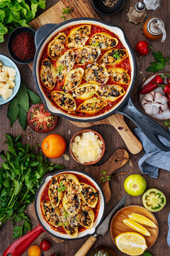 Stuffed pasta shells baked in tomato sauce with fresh ingredients.
