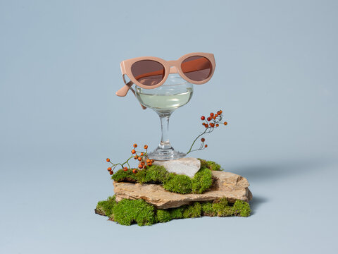 Stylish Pink Sunglasses Resting on Glass With Natural Elements