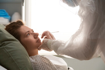 Doctor wearing ppe suit taking nasal swab test