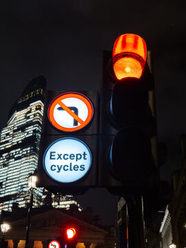 London traffic light at night with urban skyscraper backdrop