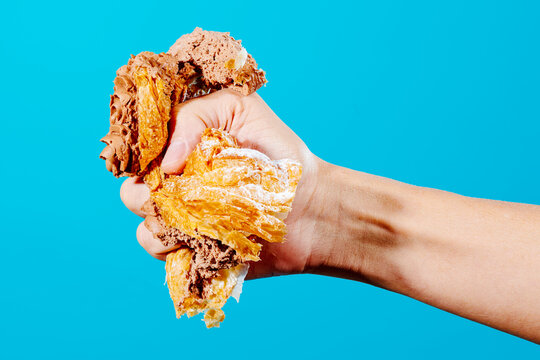 man squeezing a piece of cake with his hand