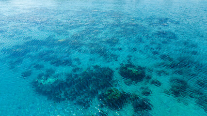 Top view, sandy beach background for summer vacation concept. Nature of beach and summer sea water with sunlight, sparkling sea water, coral reefs, underwater.