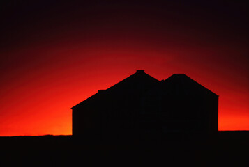 three grain bins sunset Great Plains