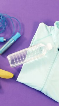 Banana, skipping rope, dumbbells, water bottle and zipper