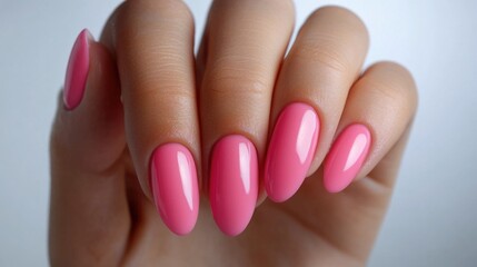 Elegant female hand showcasing vibrant pink nail polish nails against a clean white background, symbolizing beauty and self-care.