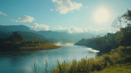 Tranquil riverscape with serene blue water reflecting sunlight and lush greenery under a clear sky in a mountainous landscape.