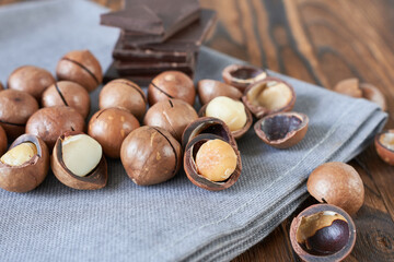 Macadamia nuts with chocolate on wooden table, close-up