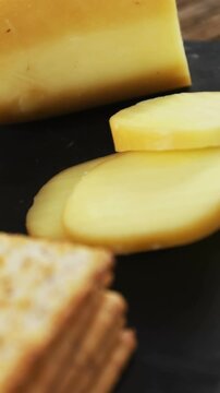 Sliced cheese with crispy biscuits, seeds, rosemary herb and sauce