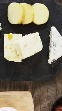 Variety of cheese, olives, biscuits and rosemary herbs on wooden table