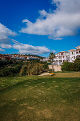 A view of La Hacienda golf course featuring a vibrant green fairway, white residential buildings,...