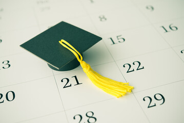 Graduation cap or mortarboard on white blank calendar background. University graduation ceremonies...