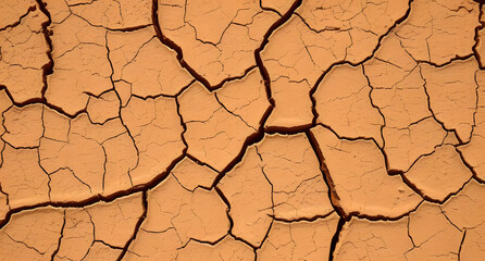 Cracked earth texture with warm orange and brown tones. Desert-inspired background.