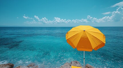 Vibrant yellow beach umbrella overlooking a clear turquoise ocean under a bright blue sky