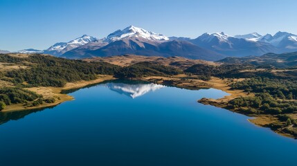 Fototapeta premium Vast serene lake reflecting snowy mountains, crystal clear blue water, perfect for nature lovers and tranquil escapes.