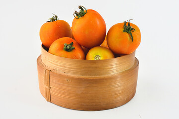 Fresh Ripe Tomatoes in a Decorative Bamboo Basket on White Background