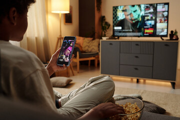 Relaxing at Home Watching TV and Checking Phone Notifications