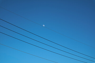 the moon on the blue sky with wires