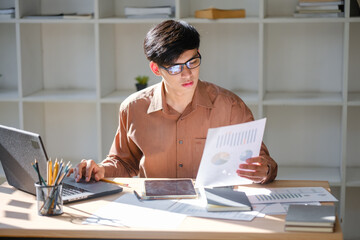 Young businessman analyzing financial data and market trends for investment decisions