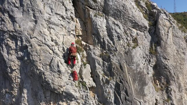 Aerial view of mountain rescuer doing rescue operations hanging on a rope