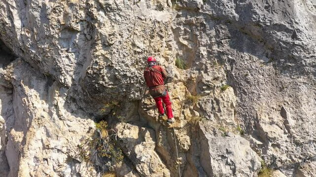 Aerial view of mountain rescuer doing rescue operations hanging on a rope