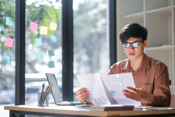 Young businessman analyzing financial data and market trends for investment decisions