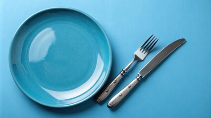 empty blue plate with knife and fork on blue background, blue hue, inanimate subject, everyday objects