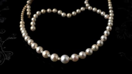 Exquisite white pearl necklace set against a dramatic deep black background with subtle silver patterns that evoke luxury and refinement, subtle elegance, high-end fashion, luxury accessories