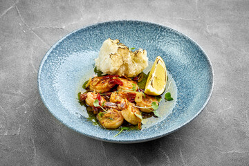 A close-up of grilled shrimp, showcasing the tender texture of the meat. The dish is garnished with...