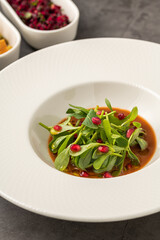 Purslane salad with olive oil and pomegranate in a white porcelain plate