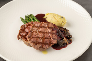 Grilled beef steak with red wine sauce, mashed potatoes, and asparagus