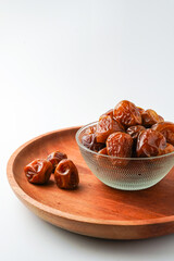Dates fruit sukari or kurma sukari, in wooden bowl isolated on white background