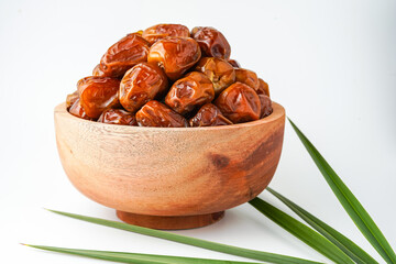 Dates fruit sukari or kurma sukari, in wooden bowl isolated on white background