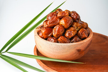 Dates fruit sukari or kurma sukari, in wooden bowl isolated on white background