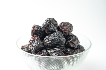 Dates fruit ajwa or kurma ajwa, in bowl isolated on white background