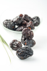 Dates fruit ajwa or kurma ajwa, in bowl isolated on white background