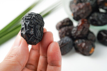 Dates fruit ajwa or kurma ajwa, in hand isolated on white background