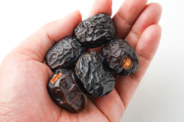 Dates fruit ajwa or kurma ajwa, in hand isolated on white background