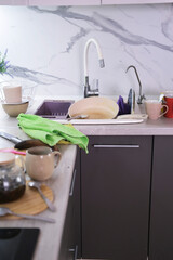 Compulsive hoarding disorder mess in kitchen. Pile of dirty dishes and pots standing on countertop in the kitchen. vertical.