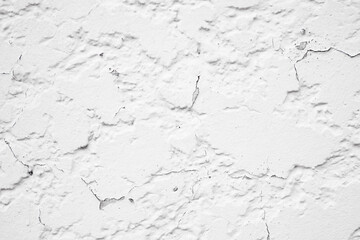 Detailed close up of cracked white textured plaster wall background