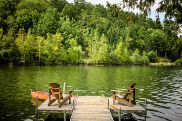 Peaceful Lake Dock with Adirondack Chairs and Canoe in Quebec © aetb
